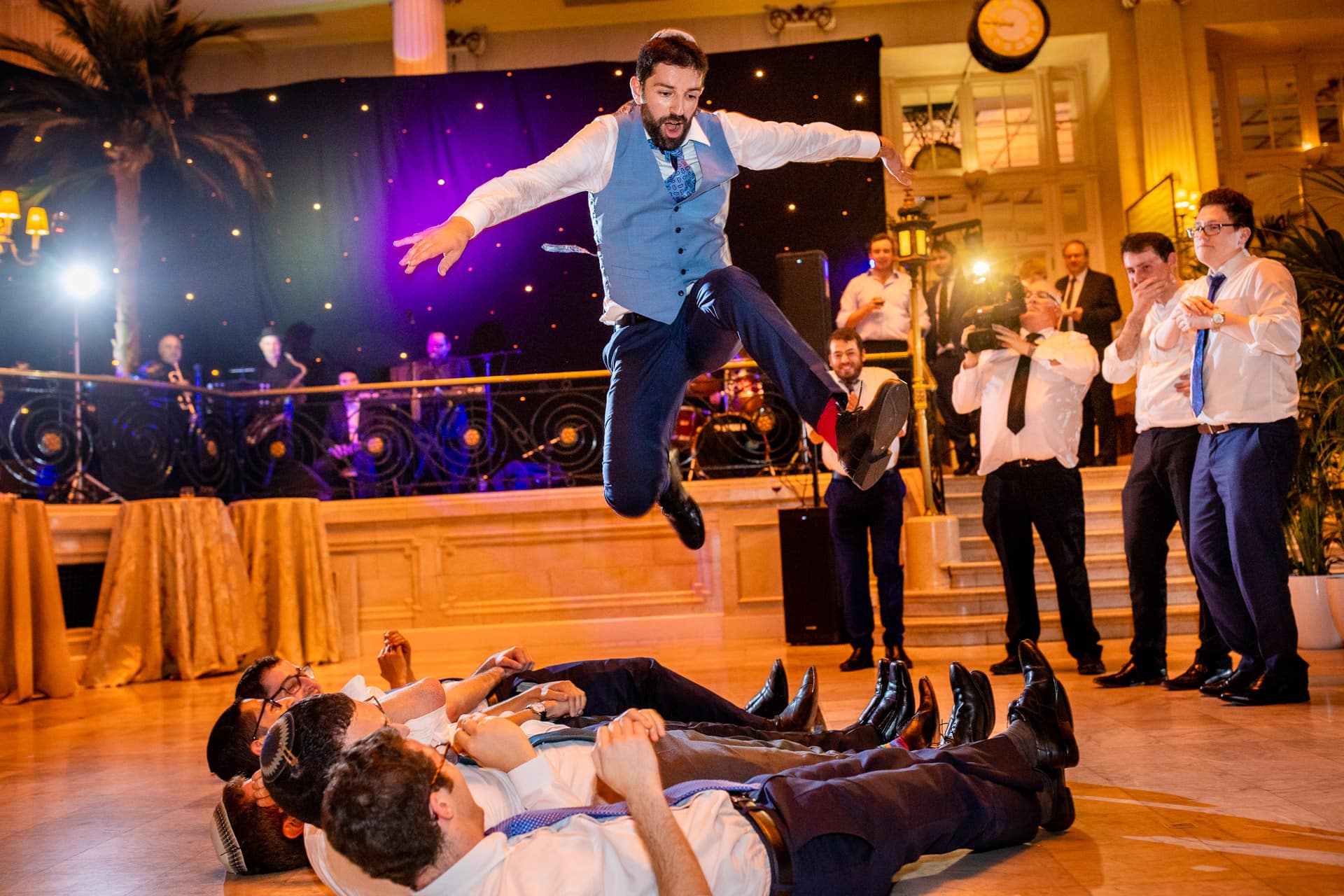 groom jumping over his friends