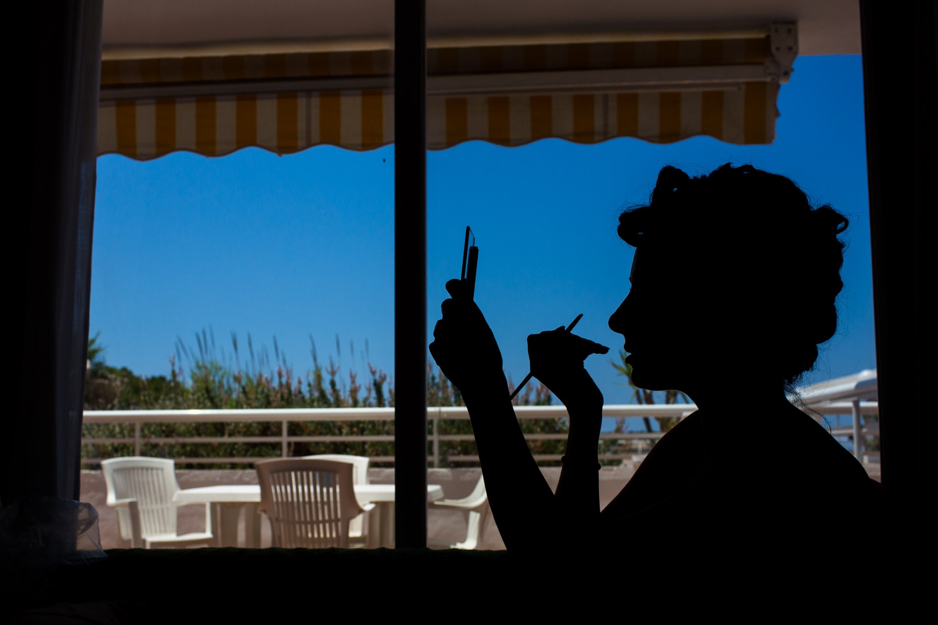silhouette of bride doing her make-up