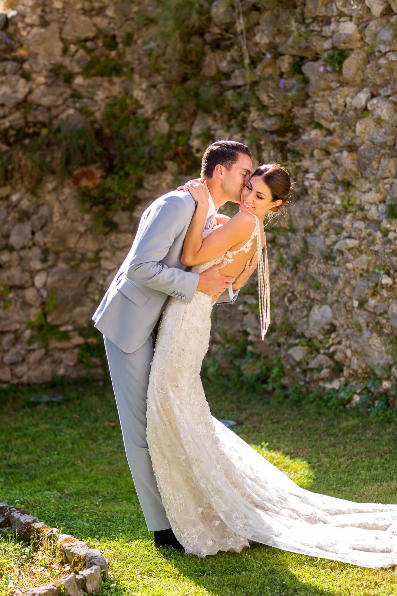 stunning wedding couple by a rustic stone wall
