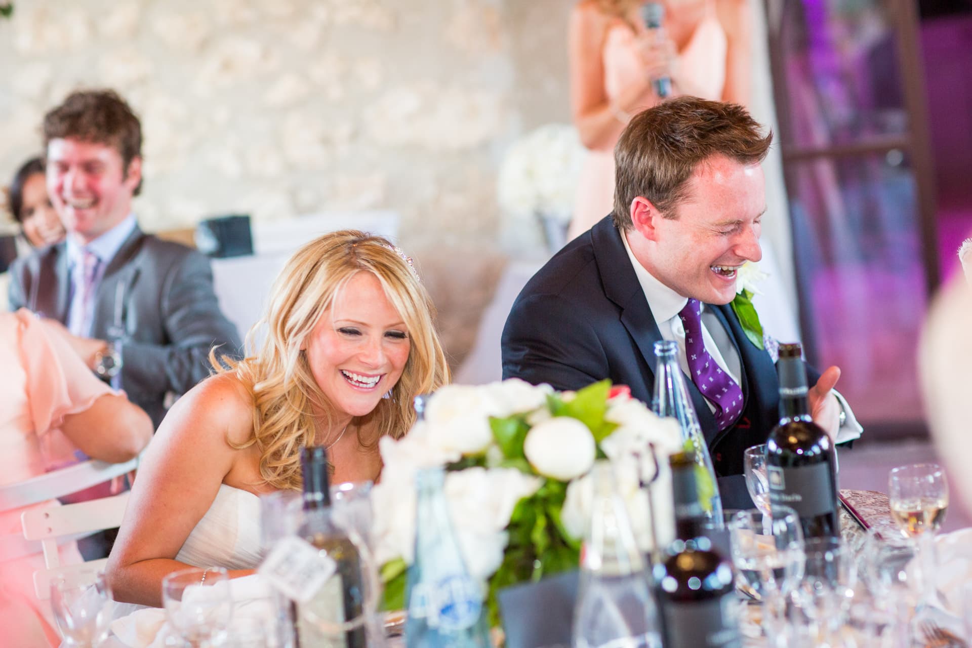 bride and groom reacting to funny speeches