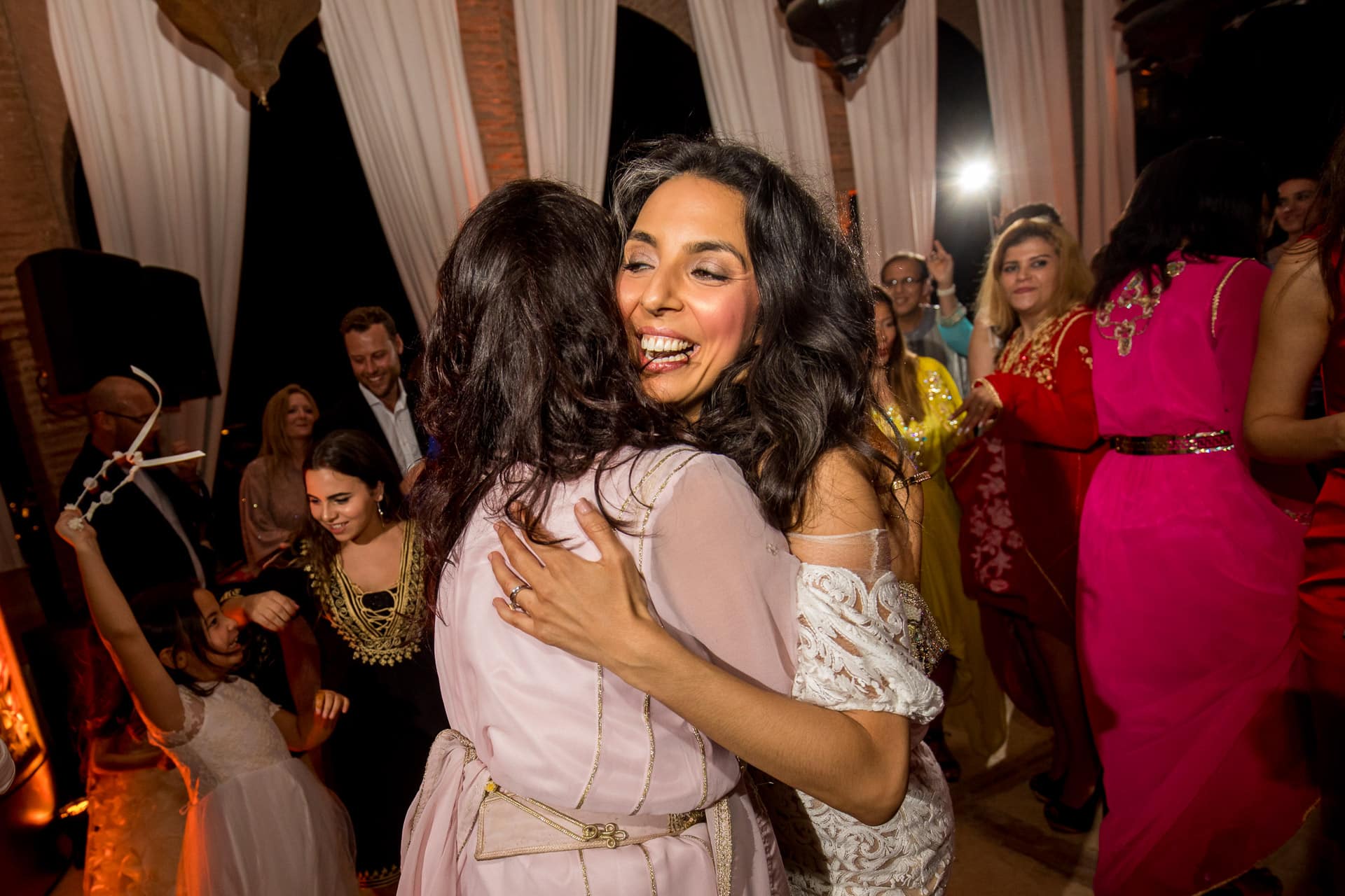bride hugging bridesmaid on dance floor