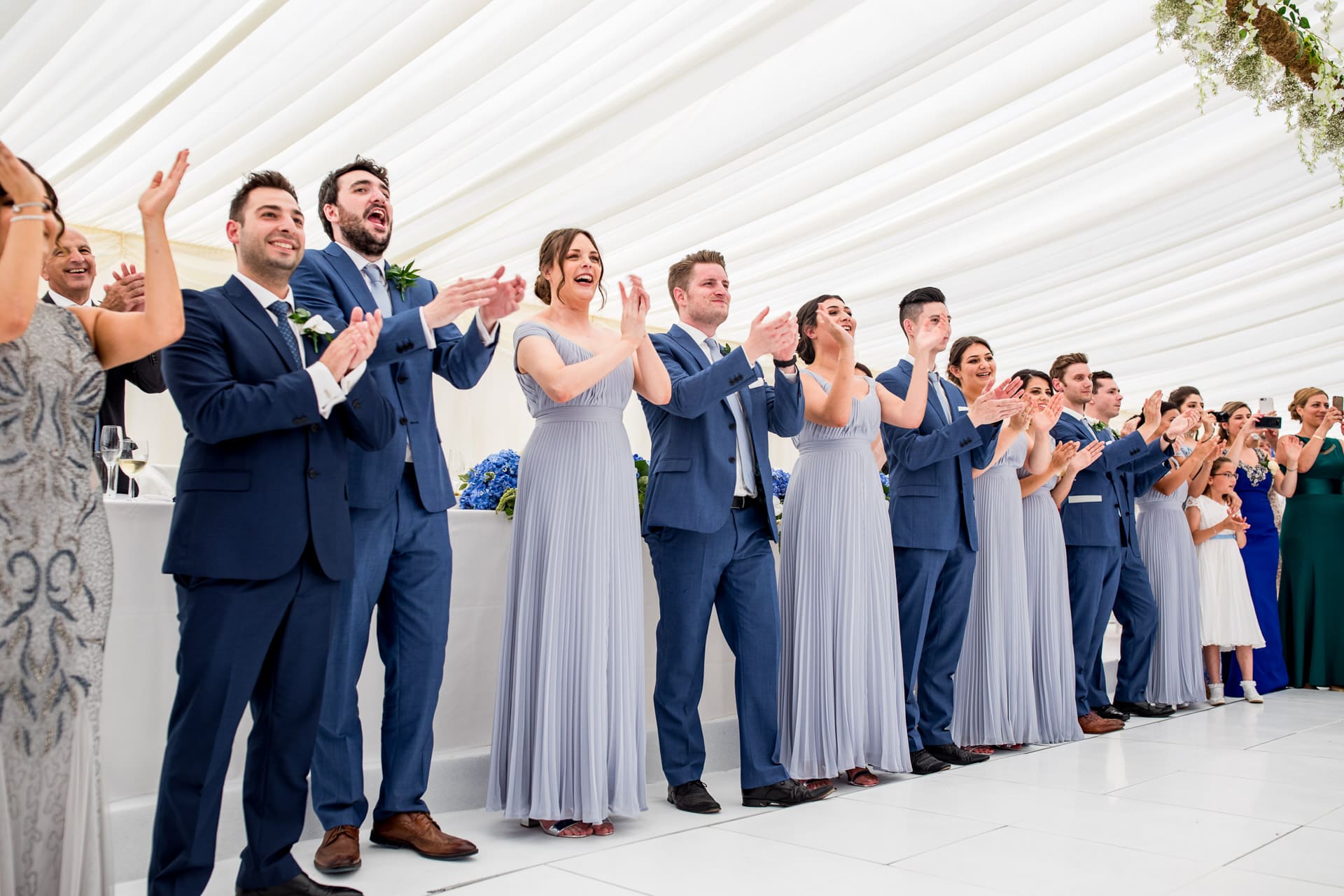 bridal party clapping in the couple