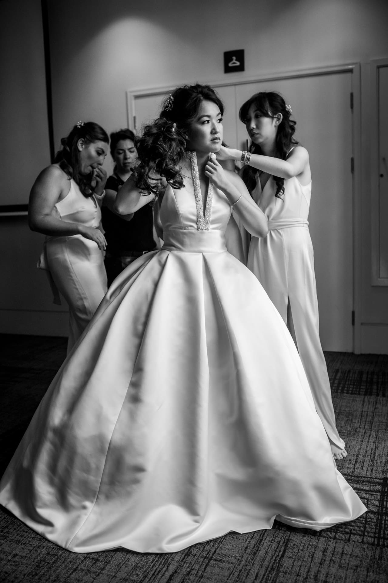 bridesmaids helping with wedding dress