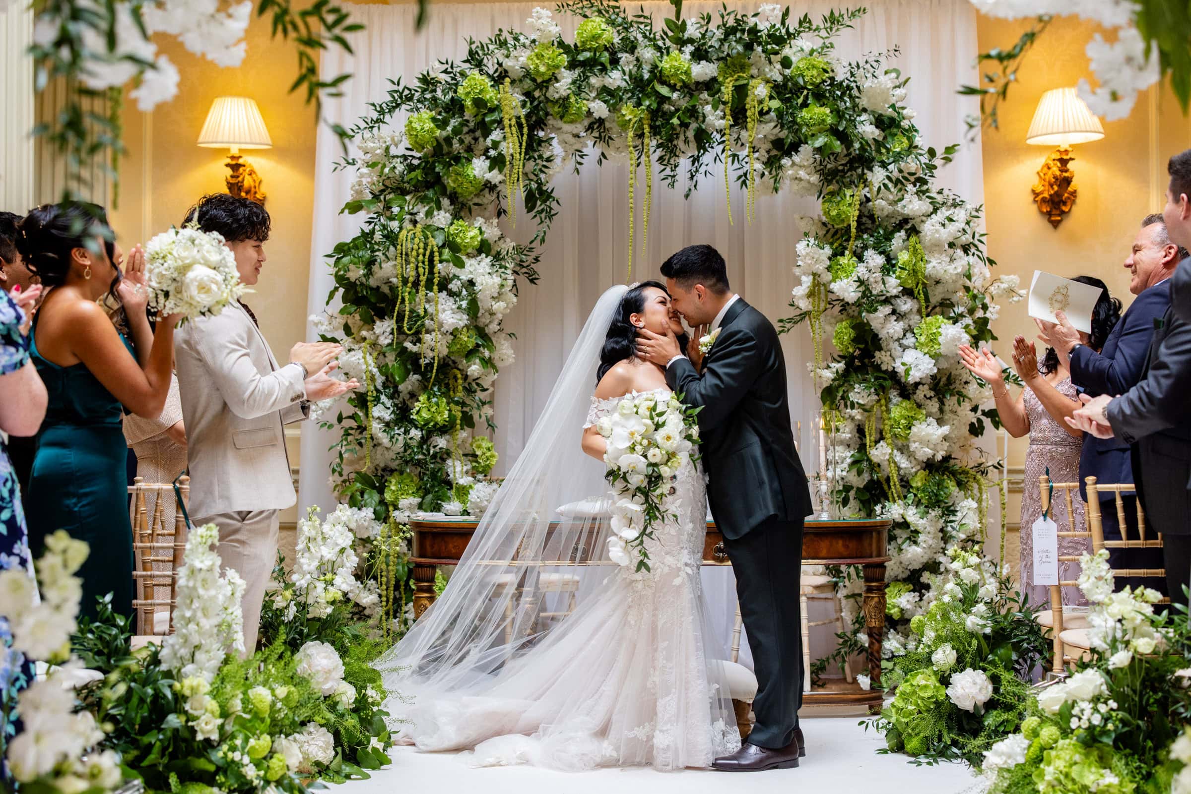 first kiss in ceremony with a big flower arch